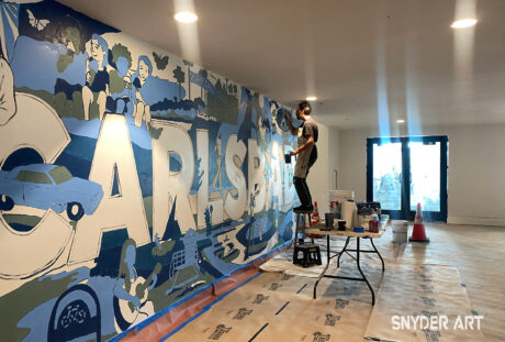 Bryan Snyder painting a mural in the Carlsbad Village